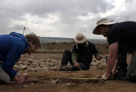 Three students at an archeology dig