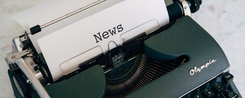 Typewriter with blank page entitled "News"