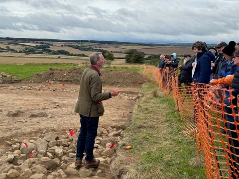 Dr. Stephen Sherlock on archeological site talking to guests