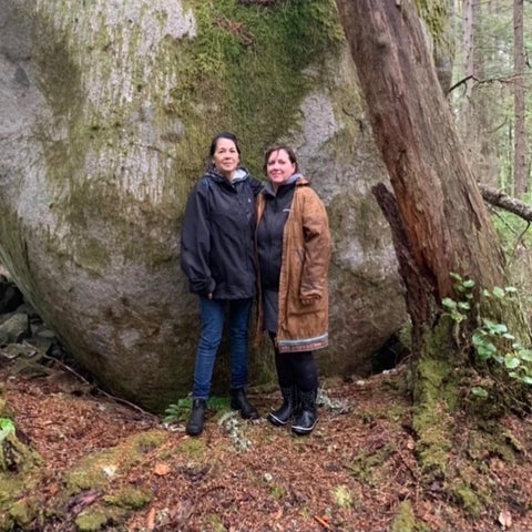 Jessica Silvey and Dr. Susan Roy stand in front of Transformer Stone, shíshálh territory.