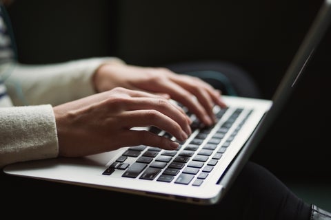 Hands typing on laptop. Photo by Kaitlyn Baker, Unsplash.