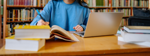 student working on a laptop in the library