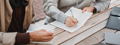 students writing notes outside