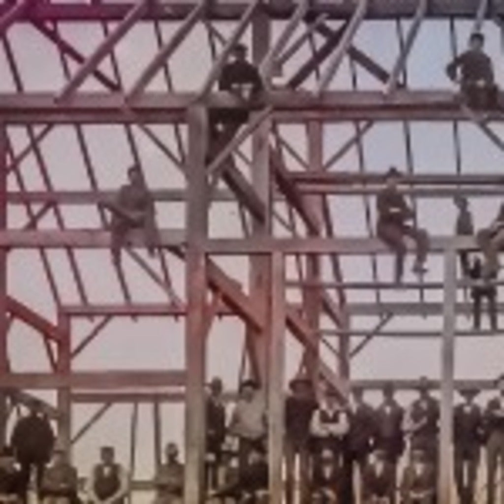 Workmen on building rafters - barnraising