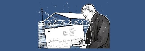 Soldier writing a letter with razor wire background