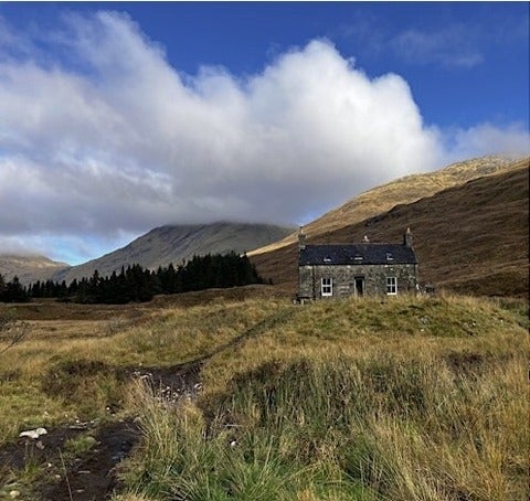Stone cottage on grassy hill, Scotland
