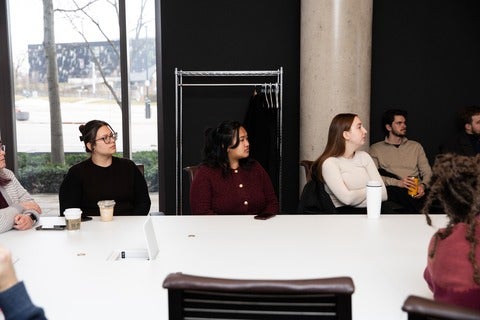 Group of people at a desk looking towards an unseen speaker