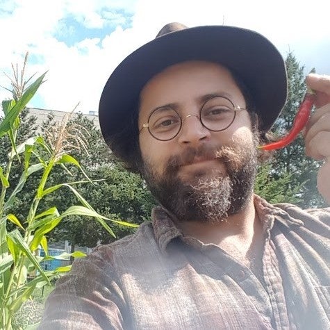 Robert Flewelling in a garden holding a hot pepper