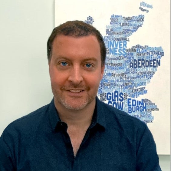 James Fraser head shot in front of blue wordle map of Scotland