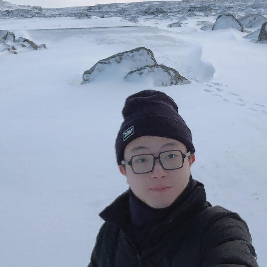 Raymond Li in winter with mountains in the background