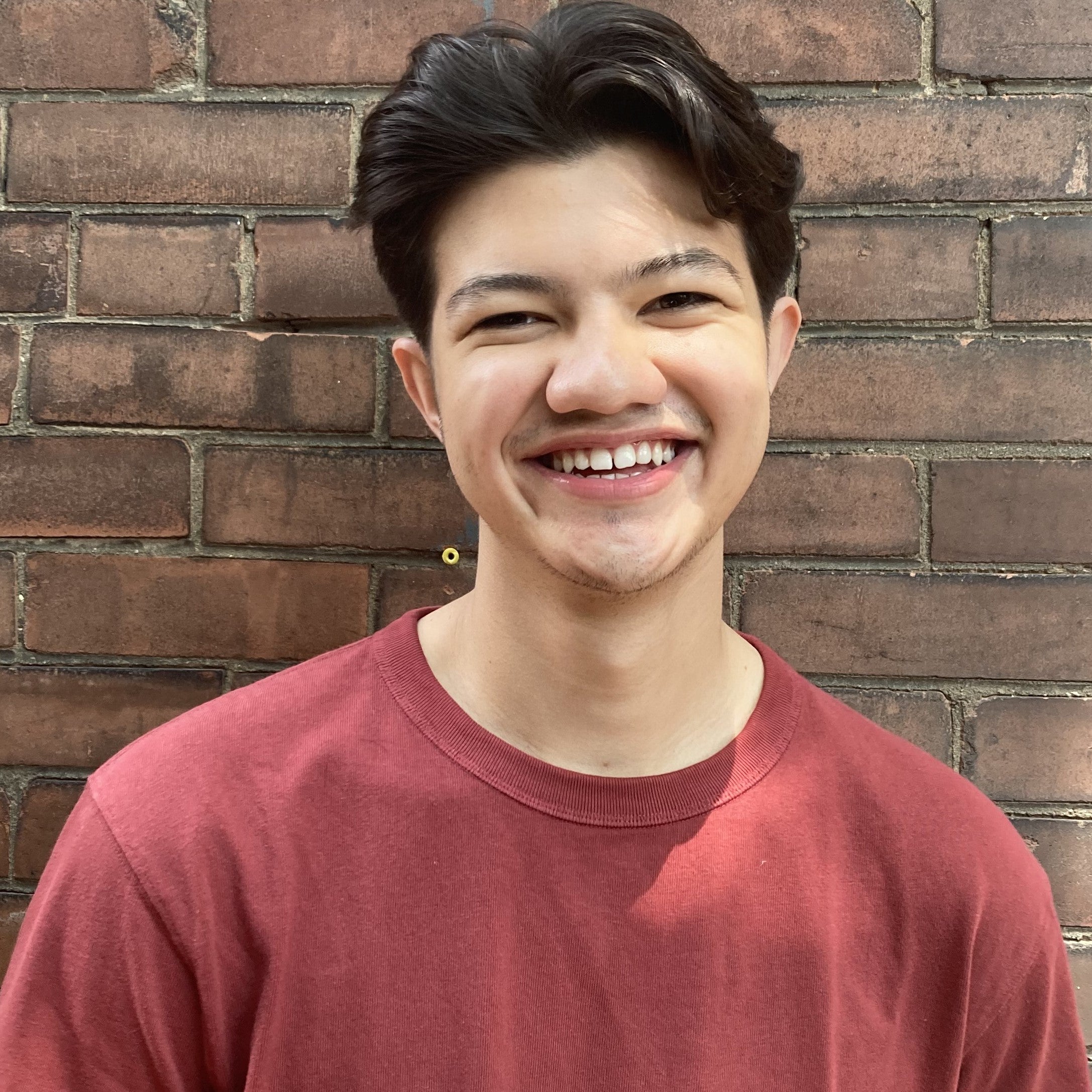 Head shot of Dylan Parry-Lai in front of a brick wall