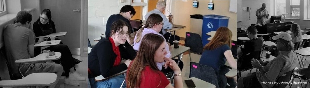 Students in a classroom, interacting. On right, professor in front; left and centre students interacting at tablet desks