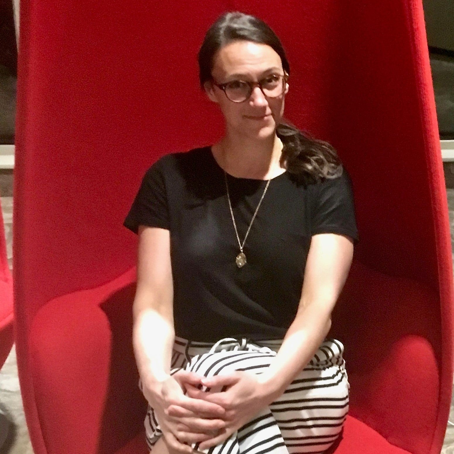 Sarah Shropshire sitting on a red chair