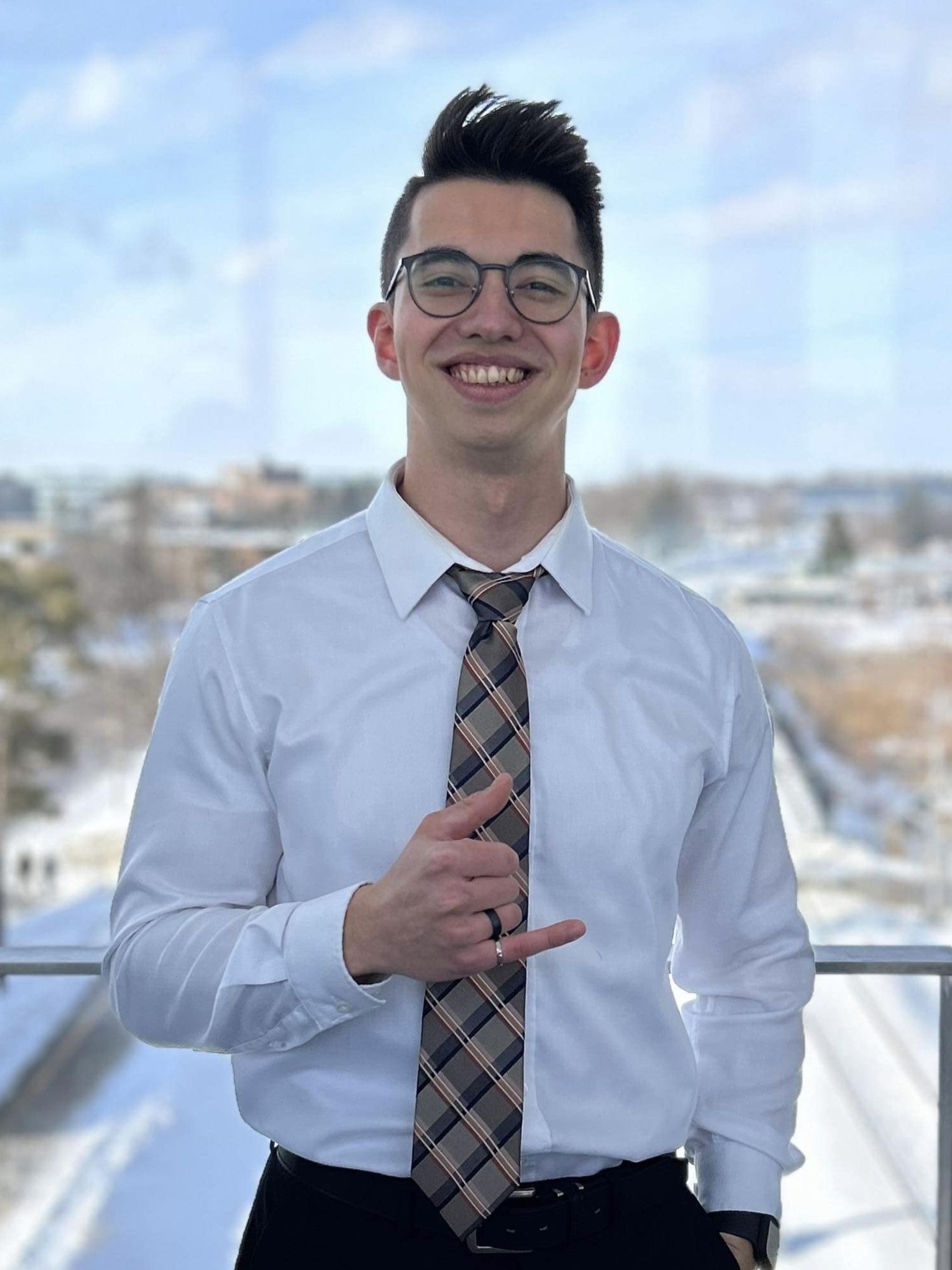 Headshot of Akira Tiesma holding up his iron ring
