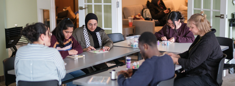 students gathered around a table crafting