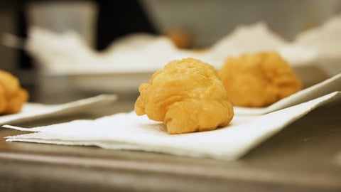 A close up image of fried bread on a white napkin