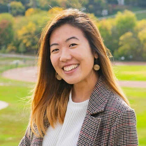 Cherie smiling with a background consisting of natural greenery
