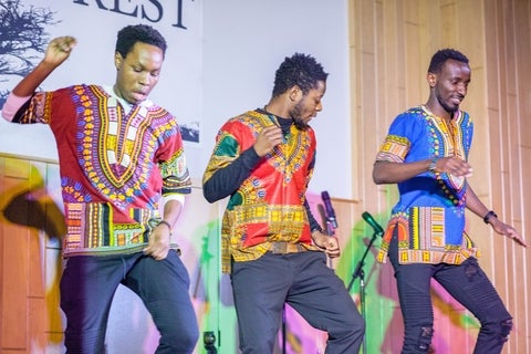 3 dancing students in African garb
