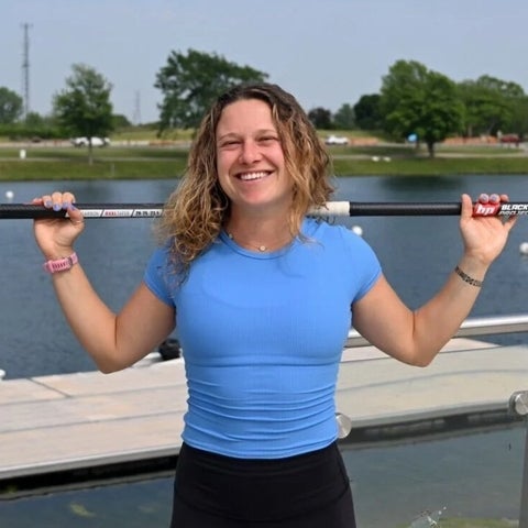 Maddi Leblanc near the water smiling and posing with a paddle