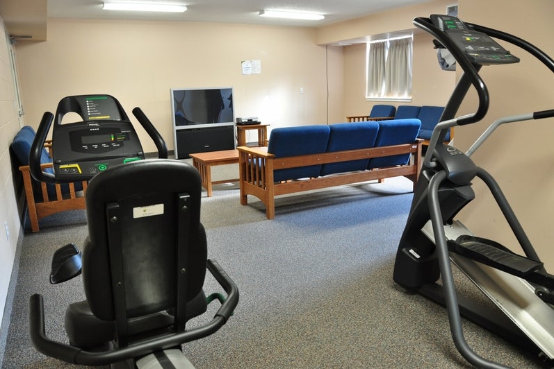 Two fitness machines overlooking a TV room