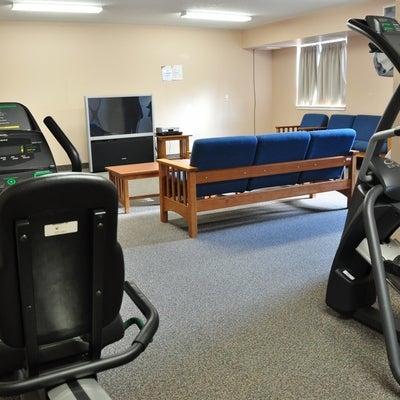 Two fitness machines overlooking a TV room