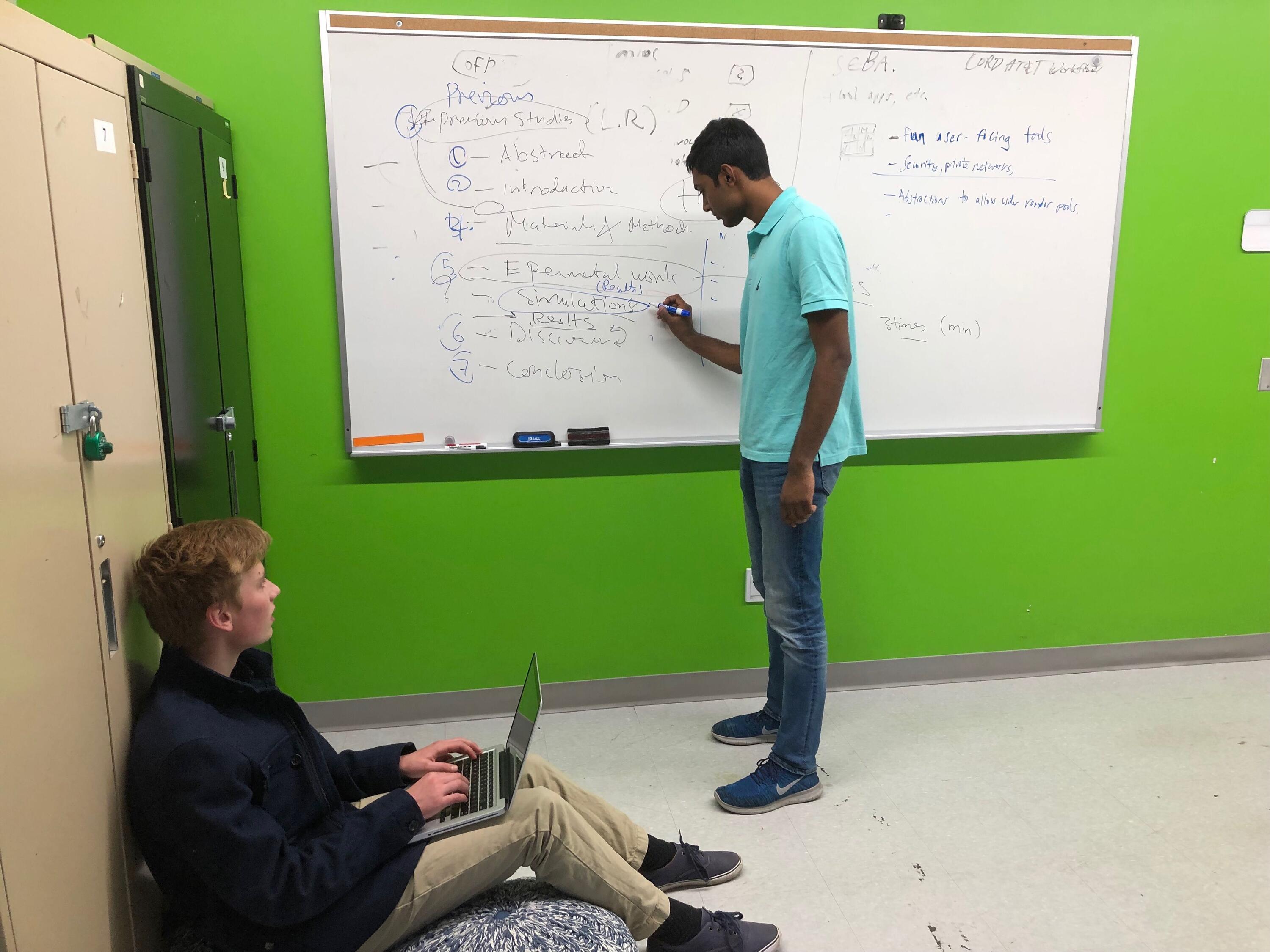 Ayush and team member working on the app on a white board