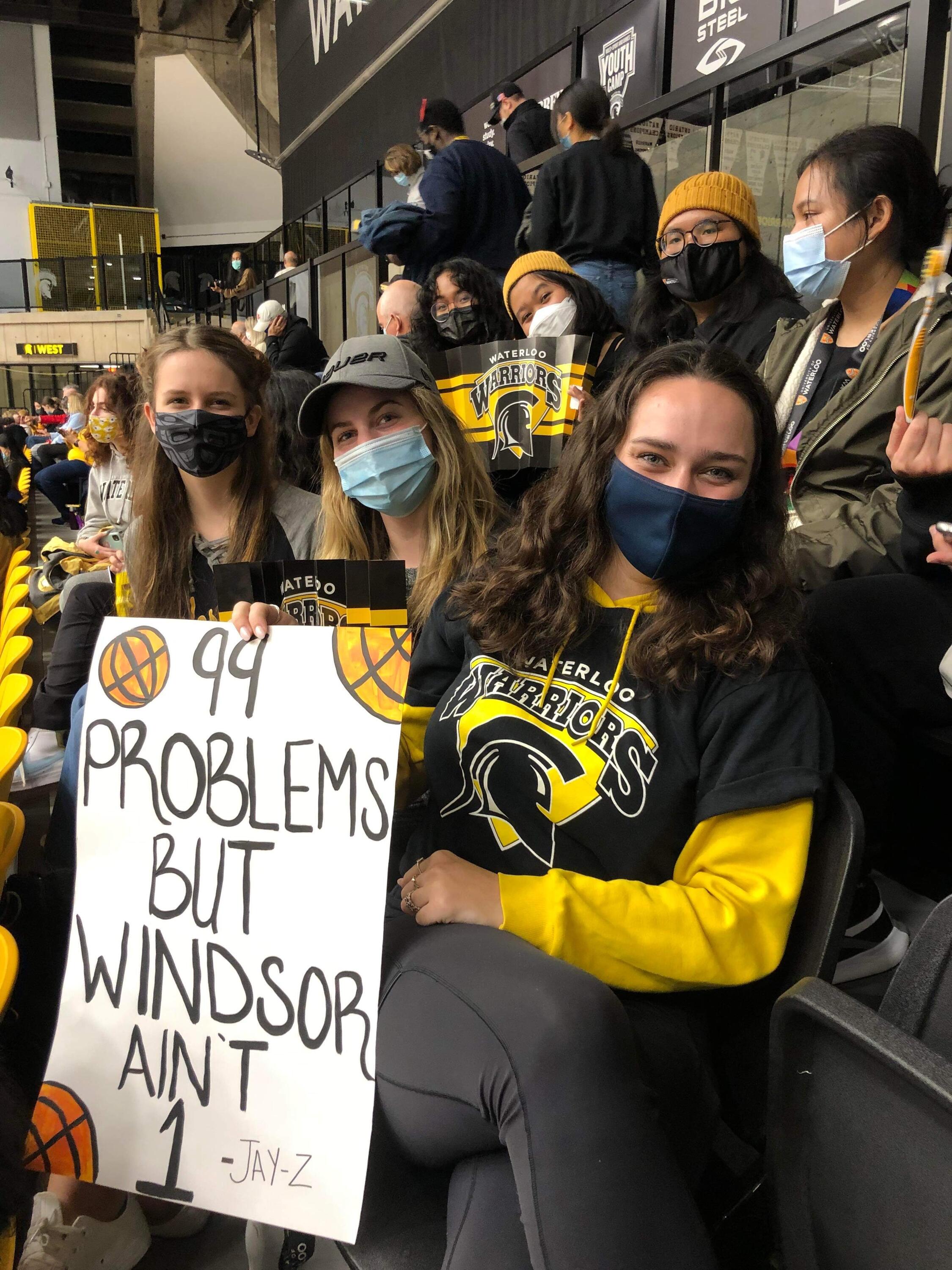 Students at the basketball game holding a sign 