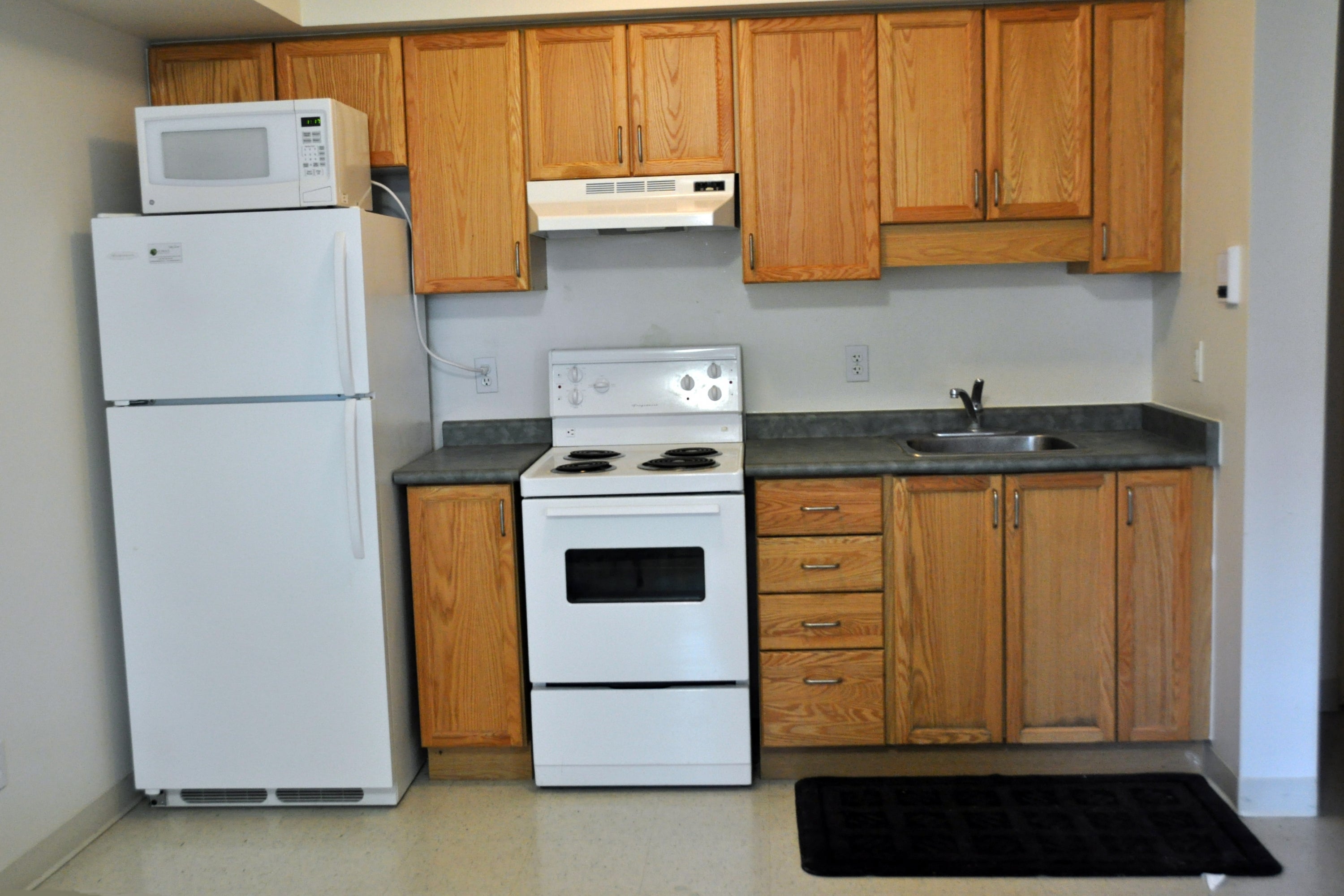 A photo of a typical kitchen, with fridge, stove and sink