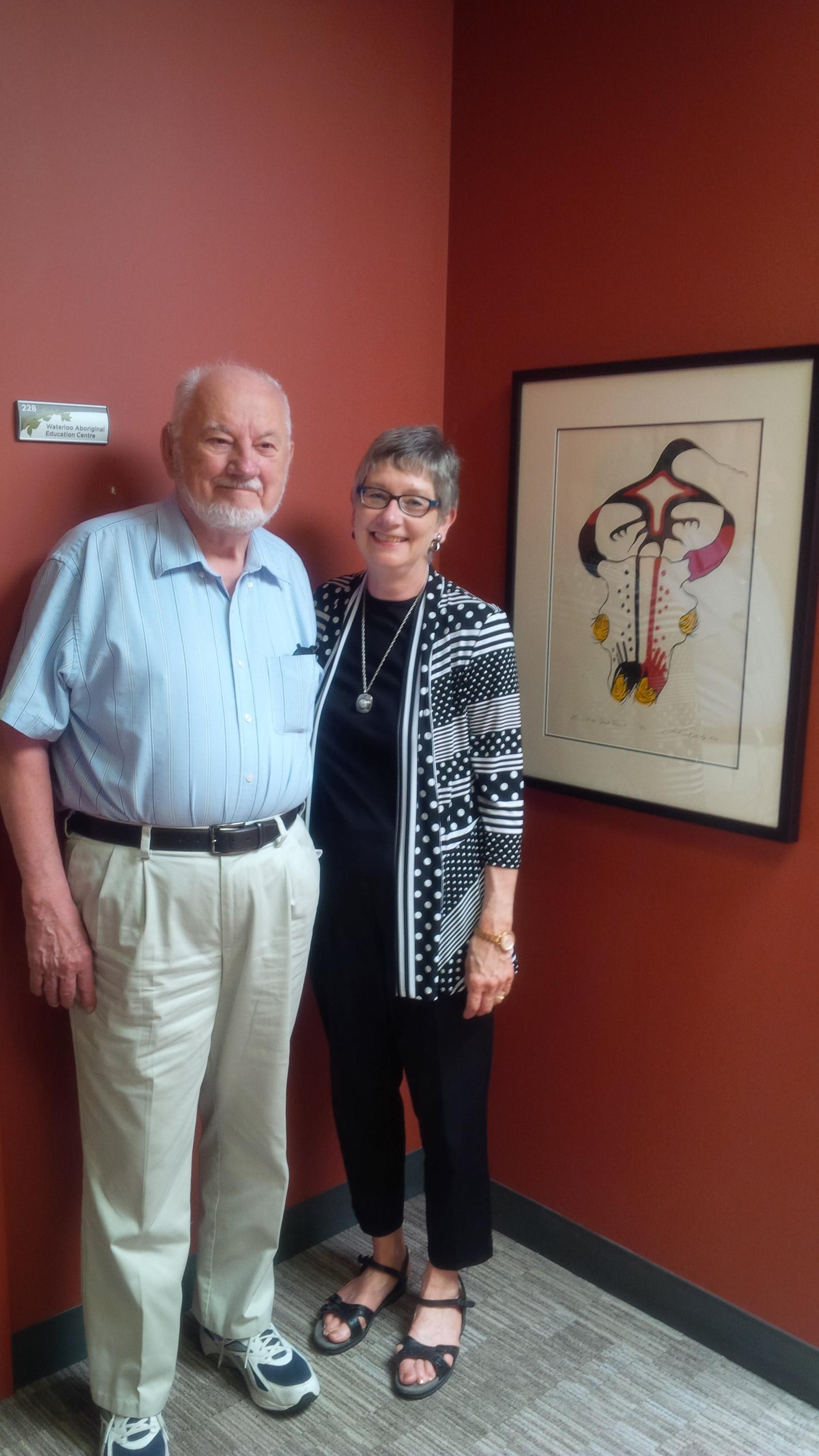 Bill Klassen and Dona Harvey stand beside donated print of Homage to the Great Spirit
