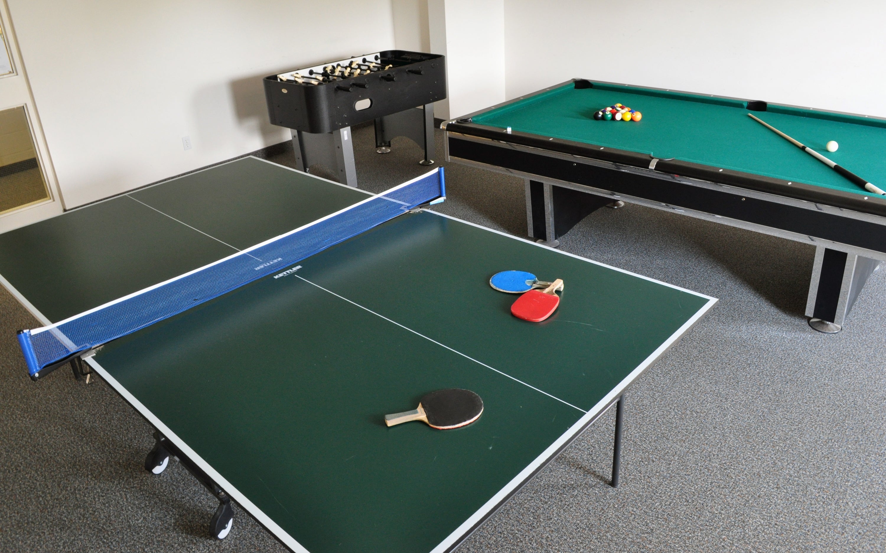 Ping pong table, with pool table behind it