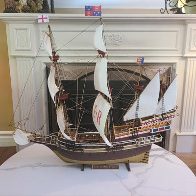 A model of a battle ship with three masts of sails 