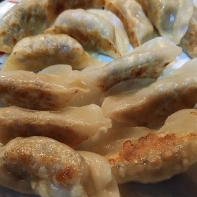 A close up of homemage dumplings in a crescent shape with lots of filling