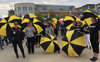Waterloo employees poser with black and gold umbrellas