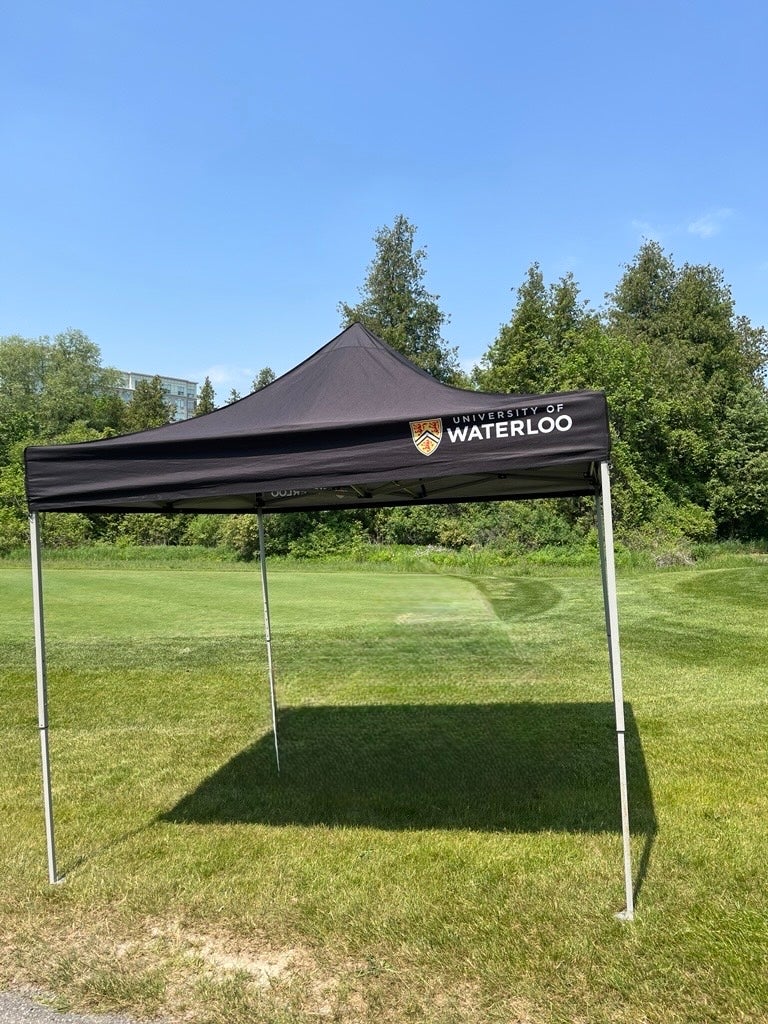 Black 4 legged tent with University of Waterloo logo 
