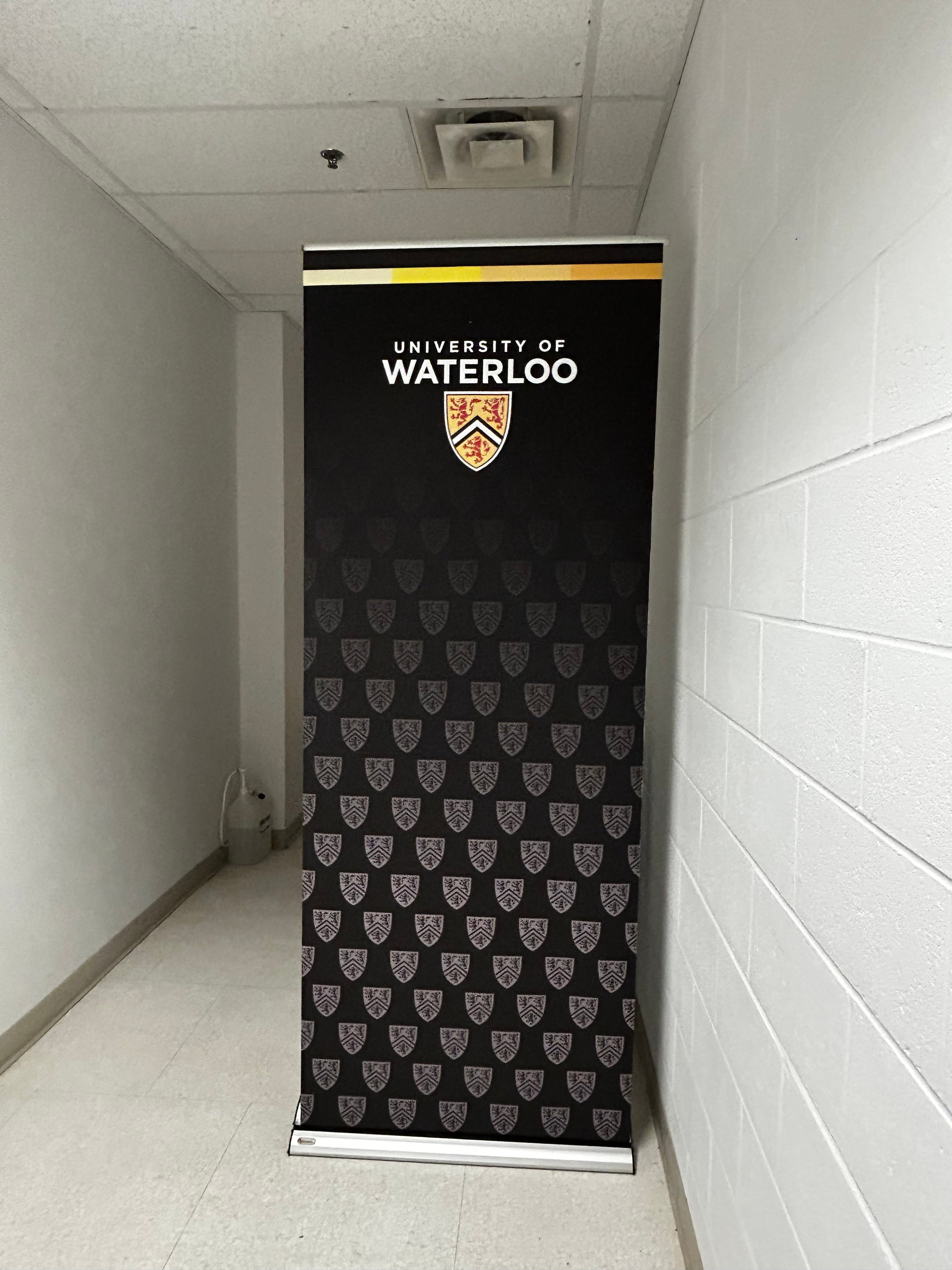Black pull up banner displaying the University of Waterloo logo with the crest at the top. 