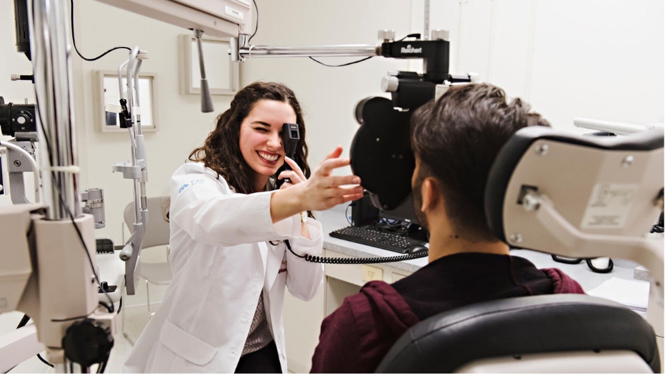 A researcher uses optometry equipment to examine a patient