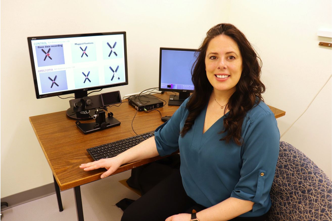Dr. Krista Kelly sits at a desk where she conducts research