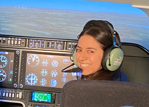 Smiling student in a flight simulator.