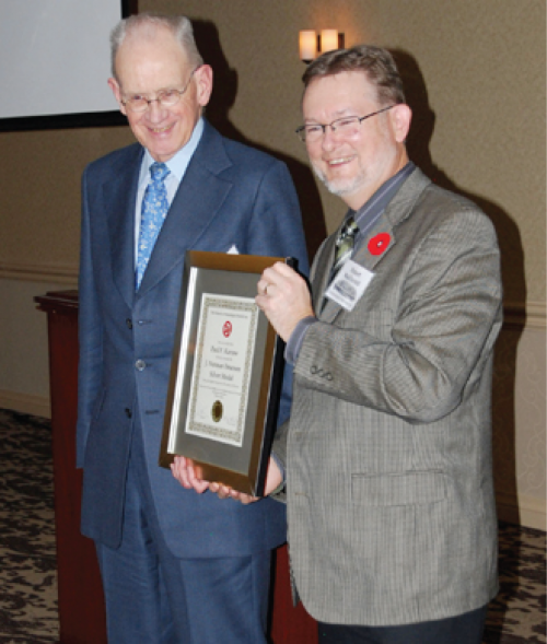 Paul Karrow receiving the award from Rob MacDonald. 