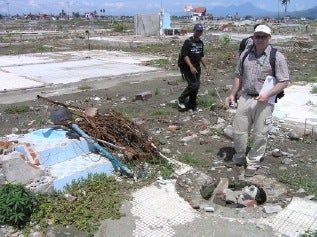 Peter Gray beside rubble filled dug well