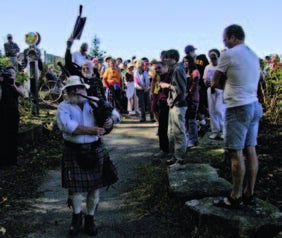 City of Waterloo surveyor (and piper), Finley MacLennan, leads the way at the opening of the GeoTime Trail.