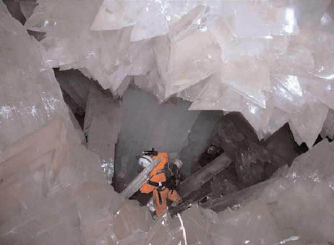 A person exploring the Naica Mine with giant crystals in foreground.