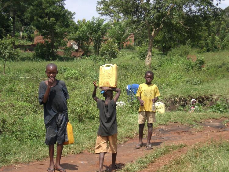 African children carrying jugs of water
