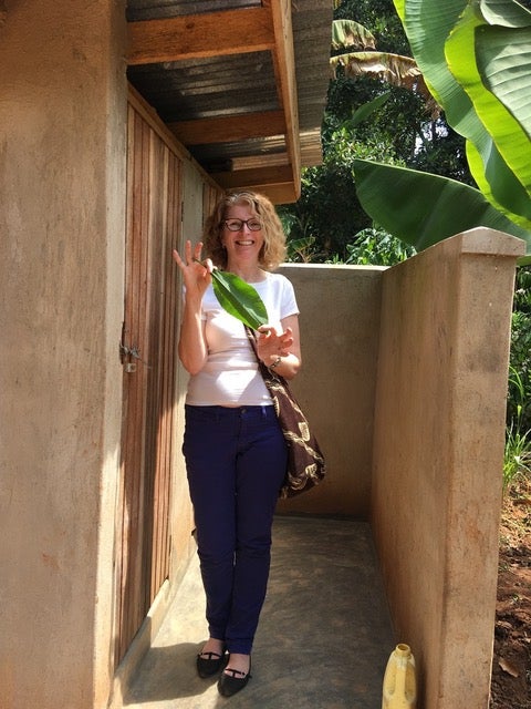 This photo is me outside a beautiful vented pit latrine and washroom with a concrete pad - the leaf is ‘toilet paper;