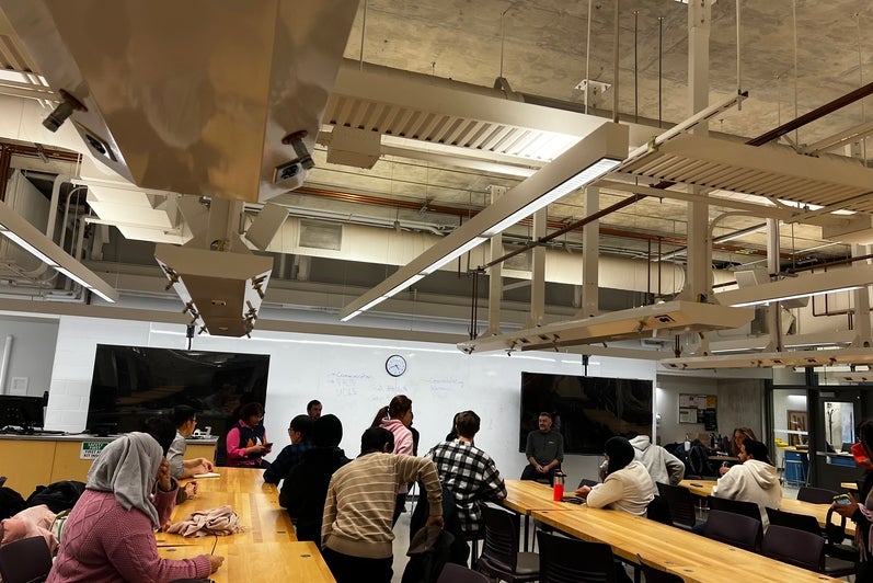 Image of the panel event organized, students sitting at tables listening to the panel