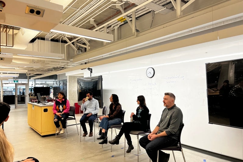Image of the panel event organized, students sitting at tables listening to the panel