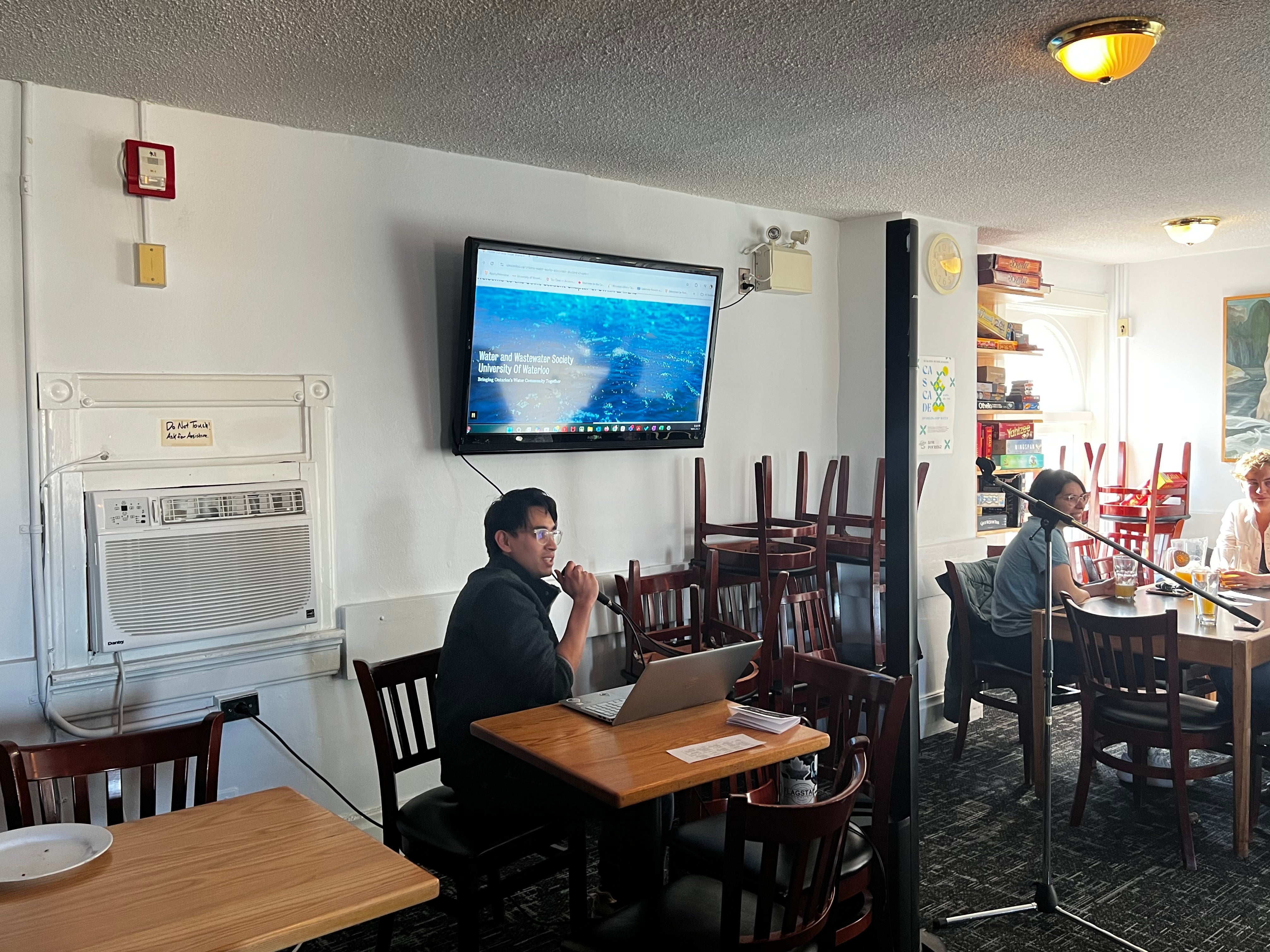 Karaoke event-host next to the karaoke machine holding a microphone