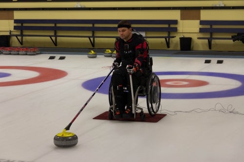Paralympic curler on ice in wheelchair