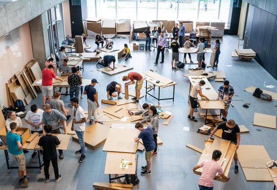 Large group of students working with pieces of cardboard