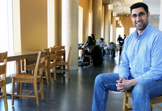 Nasser Abukhdeir sits in a chair along a hallway